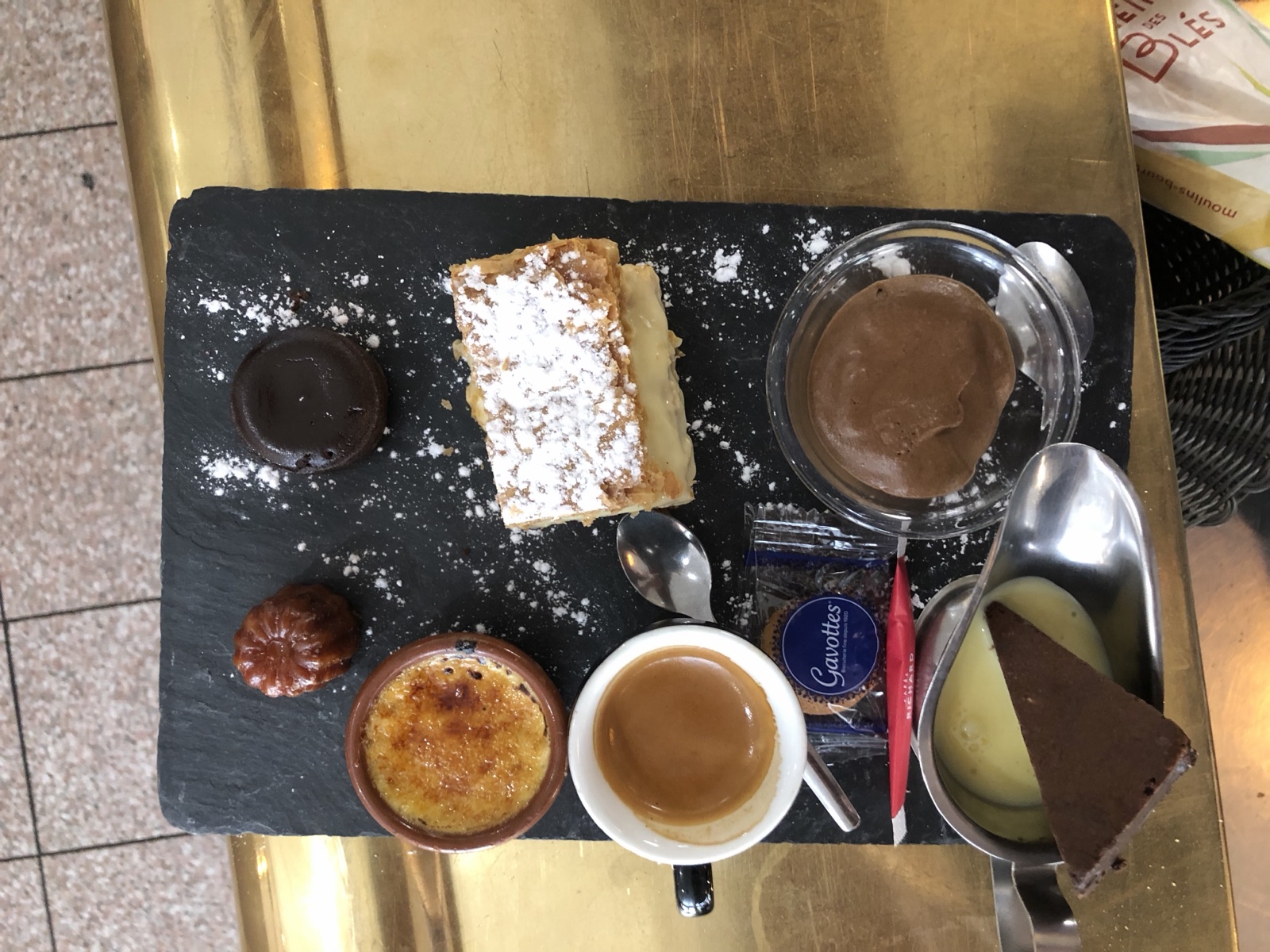 Café gourmand sur ardoise : espresso, mille-feuille, crème brûlée, mousse au chocolat, tarte au chocolat, cannelé et crème anglaise