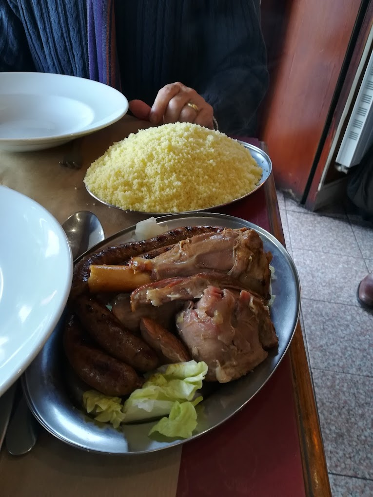 Couscous traditionnel servi avec semoule fine, agneau et merguez