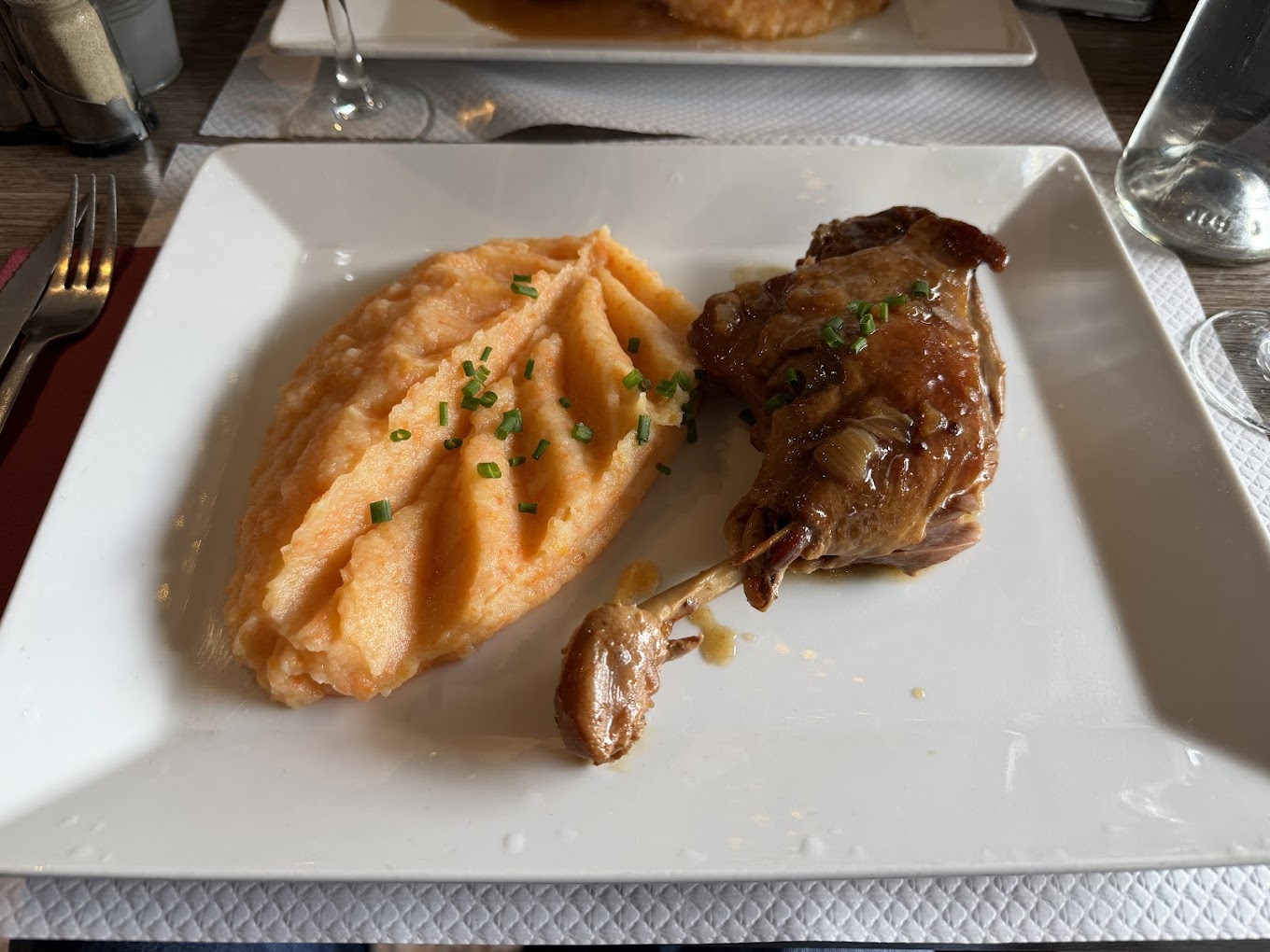 Confit de canard servi avec une purée maison aux herbes